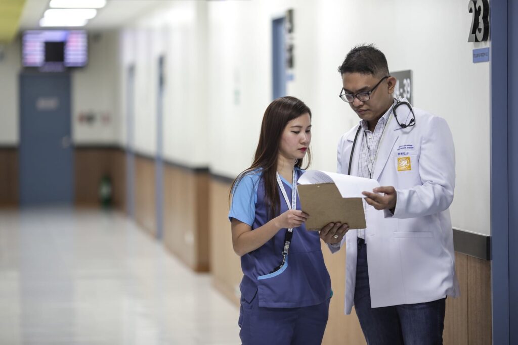 doctor talking with physicians assistant in a hallway